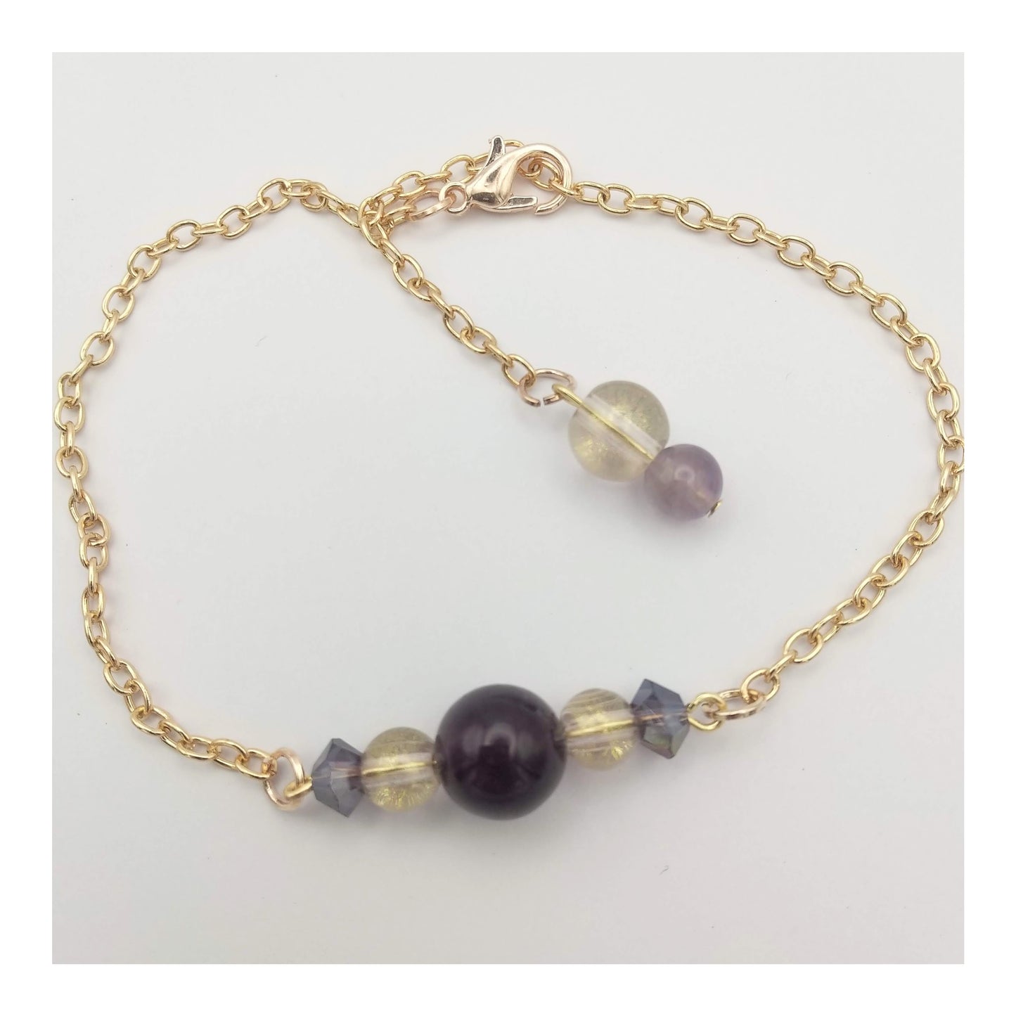 Amethyst, clear golden shimmer and iridescent purple beads on an adjustable extra long 11 inch gold toned chain with matching small amethyst and clear golden shimmer beads on the end of the chain.  