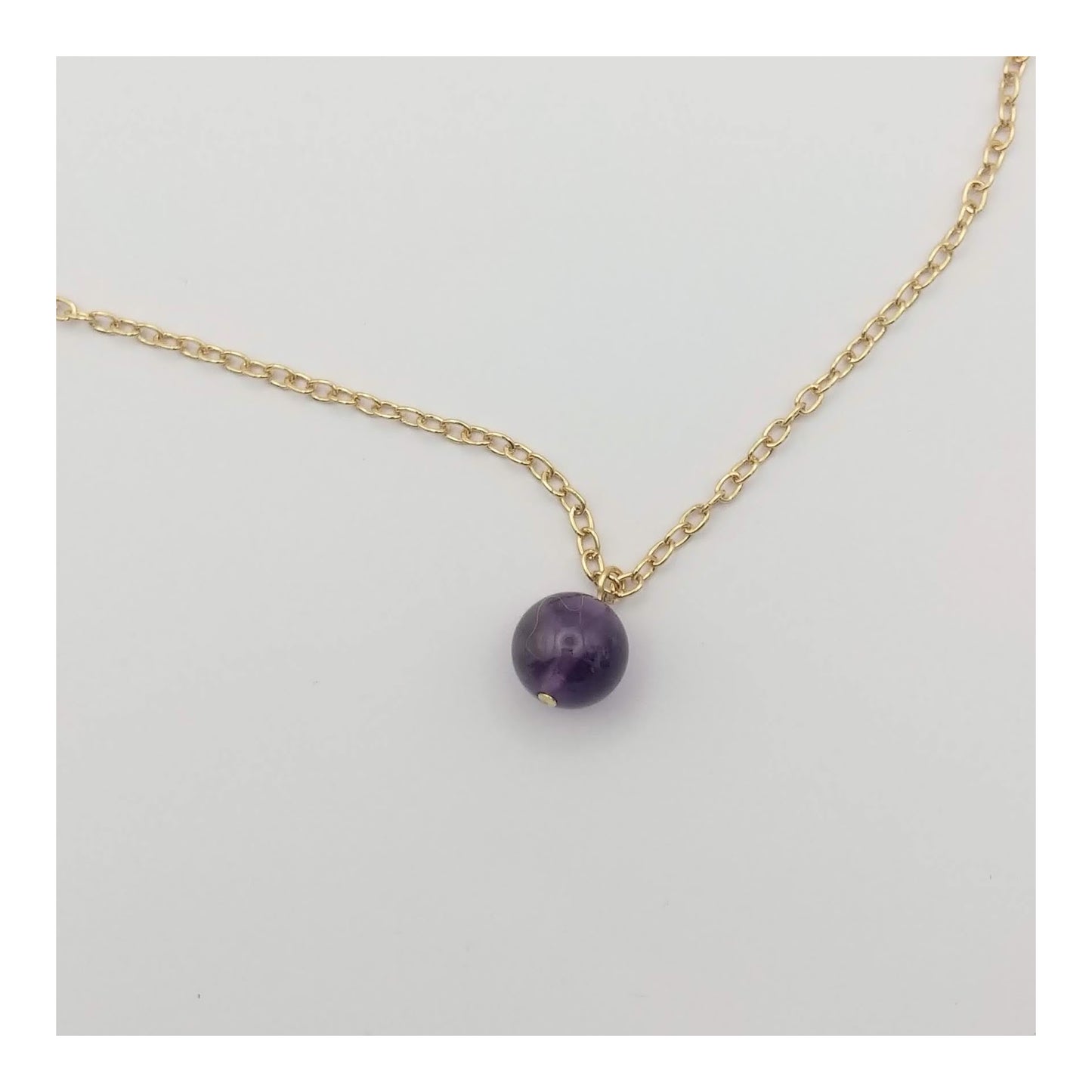 1 cm Amethyst bead on an adjustable gold toned chain with a maximum length of 24 inches. 