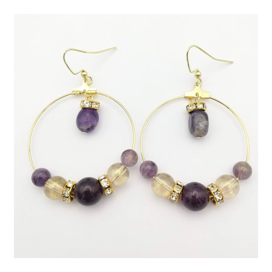 Round Amethyst, lavender and gold colored accented beads in a symmetrical pattern on 1 1/2 inch diameter thin gold hoop. With a small oblong amethyst bead, hanging for the top of the hoop, on gold toned fish hooks totally a 2 ½ inch drop. 