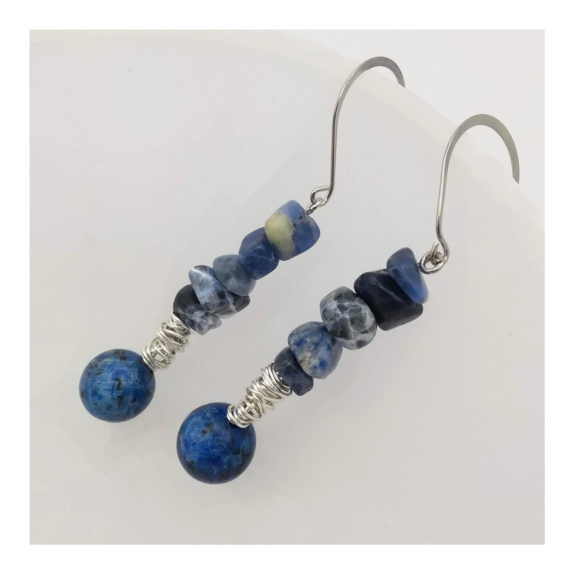 Gorgeous blue and white sodalite chips and round lapis lazuli bead divided by silver toned wire wrapping sprung on fish hook earrings equaling a 2 ½ inch drop.   